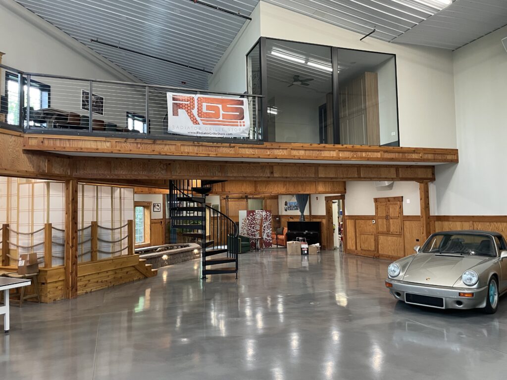 Second floor home addition with glass walls overlooking garage and cars below