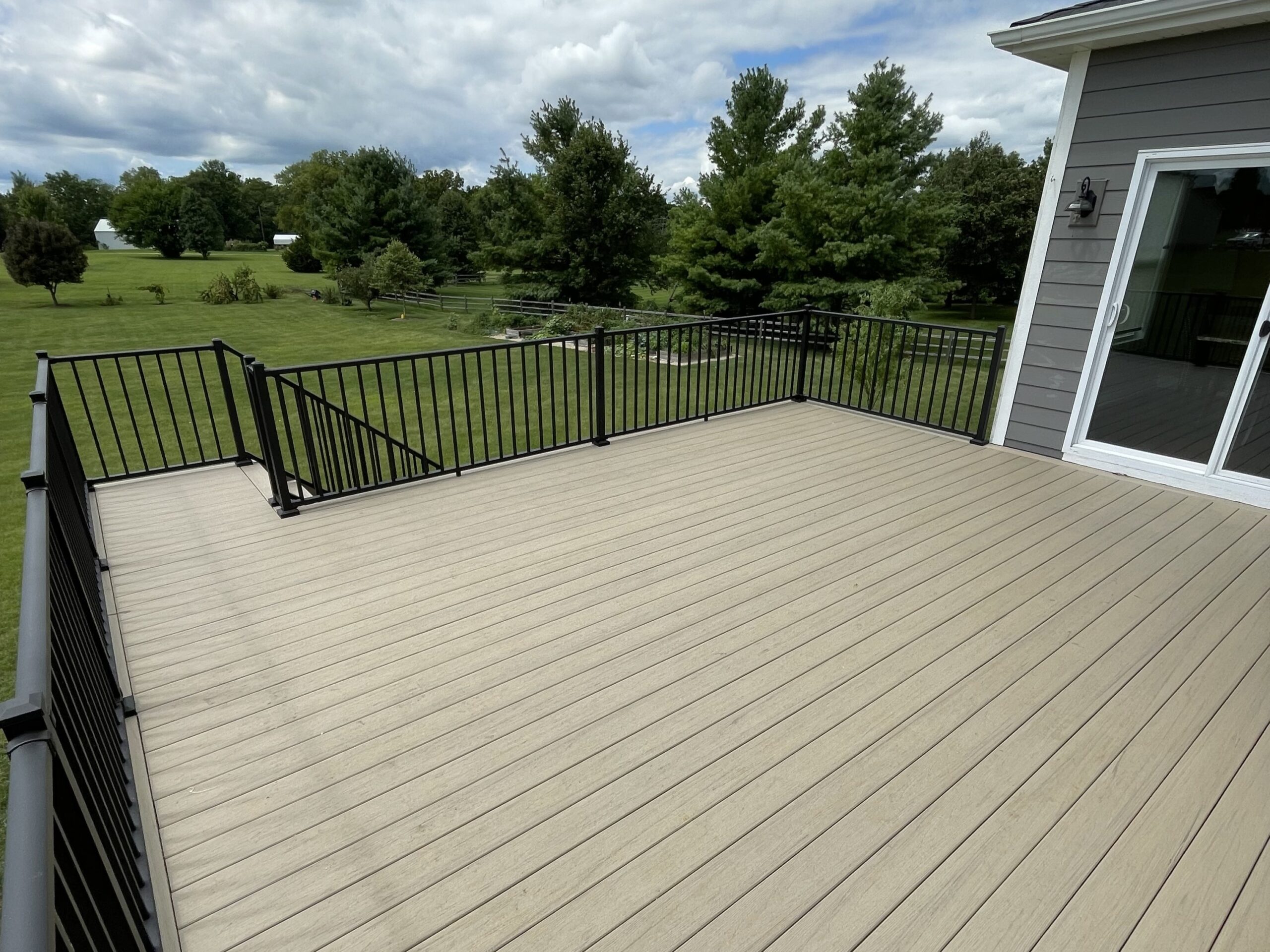 Low-maintenance composite deck installation in Yorkville Illinois with realistic wood grain and black railings.