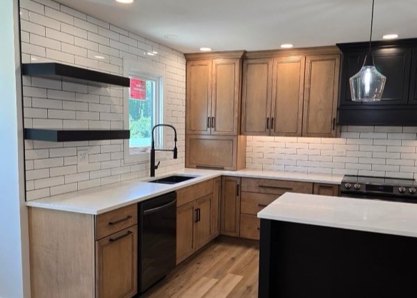 Custom kitchen remodel in Oswego, IL with floating wood shelves, matte black hardware, black sink and faucet, and white brick backsplash with dark grout