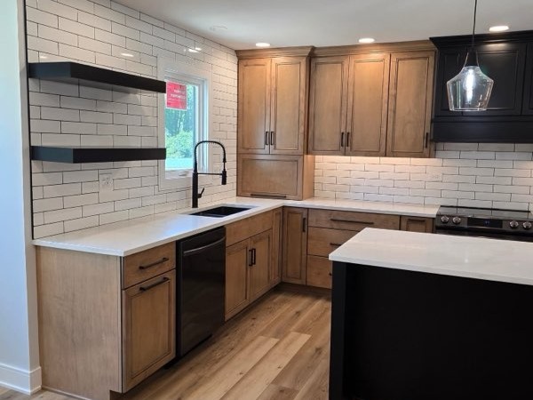 Custom kitchen renovation in Oswego Illinois with floating shelves, black hardware, farmhouse sink, and white brick backsplash.