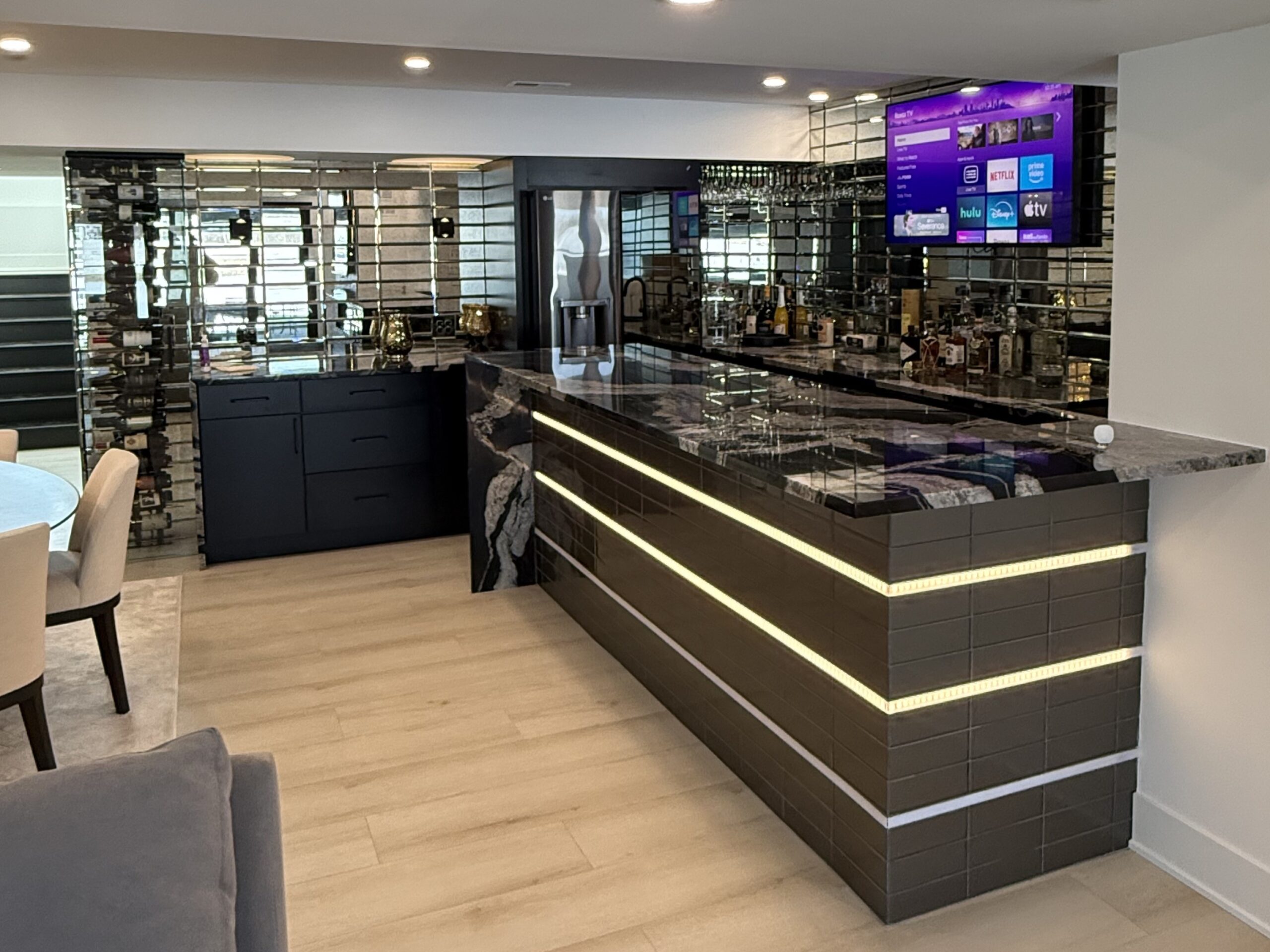Custom basement bar remodel in Oswego, IL with LED accent lighting, wine rack, and luxury countertop surfacesv