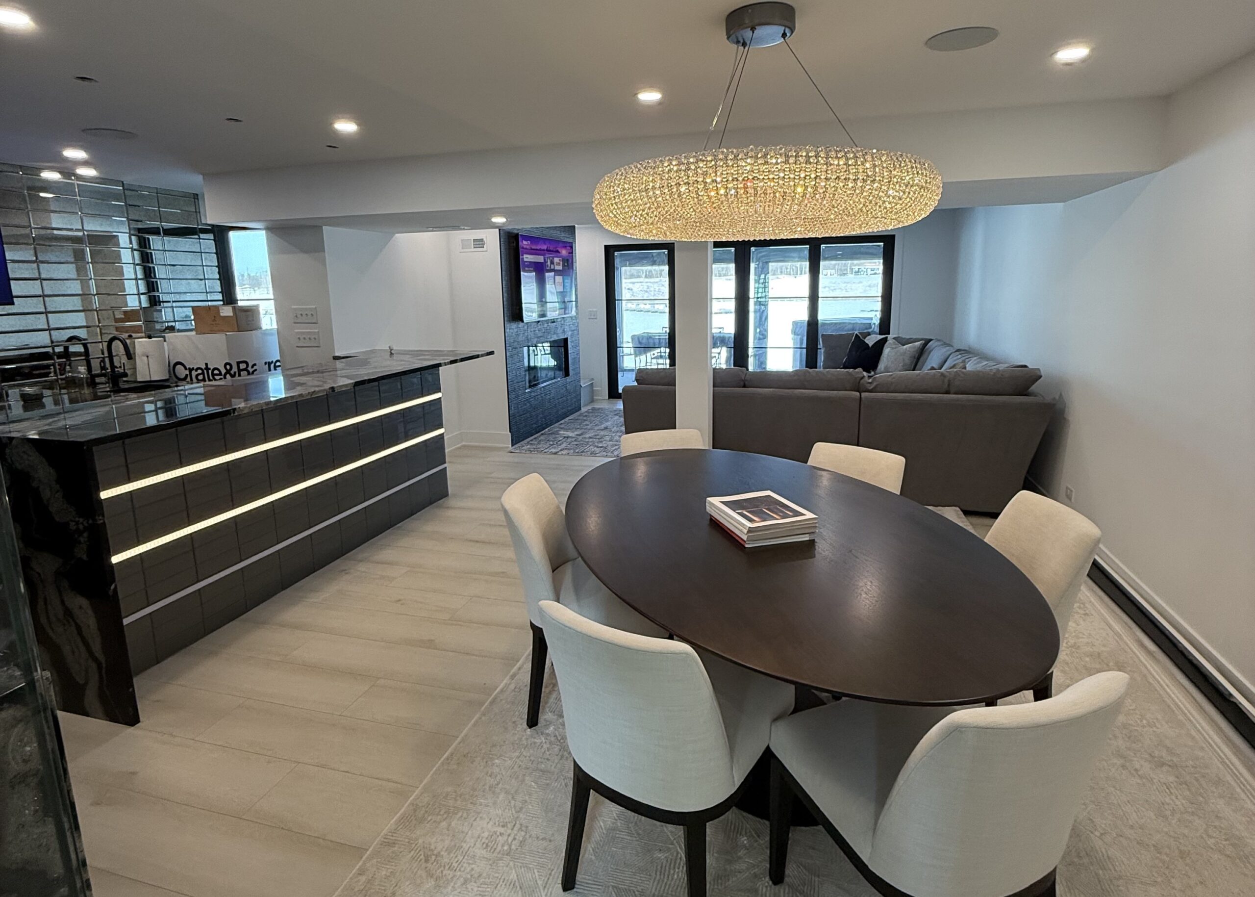 Custom finished basement in Ottawa, IL with black cabinetry bar, open sitting area, and large L-shaped sectional