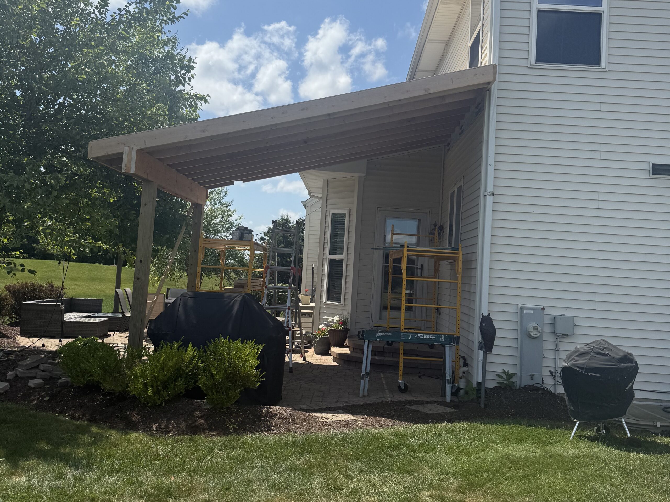 Custom-built wooden patio roof in Oswego, IL, providing shade and outdoor living space.