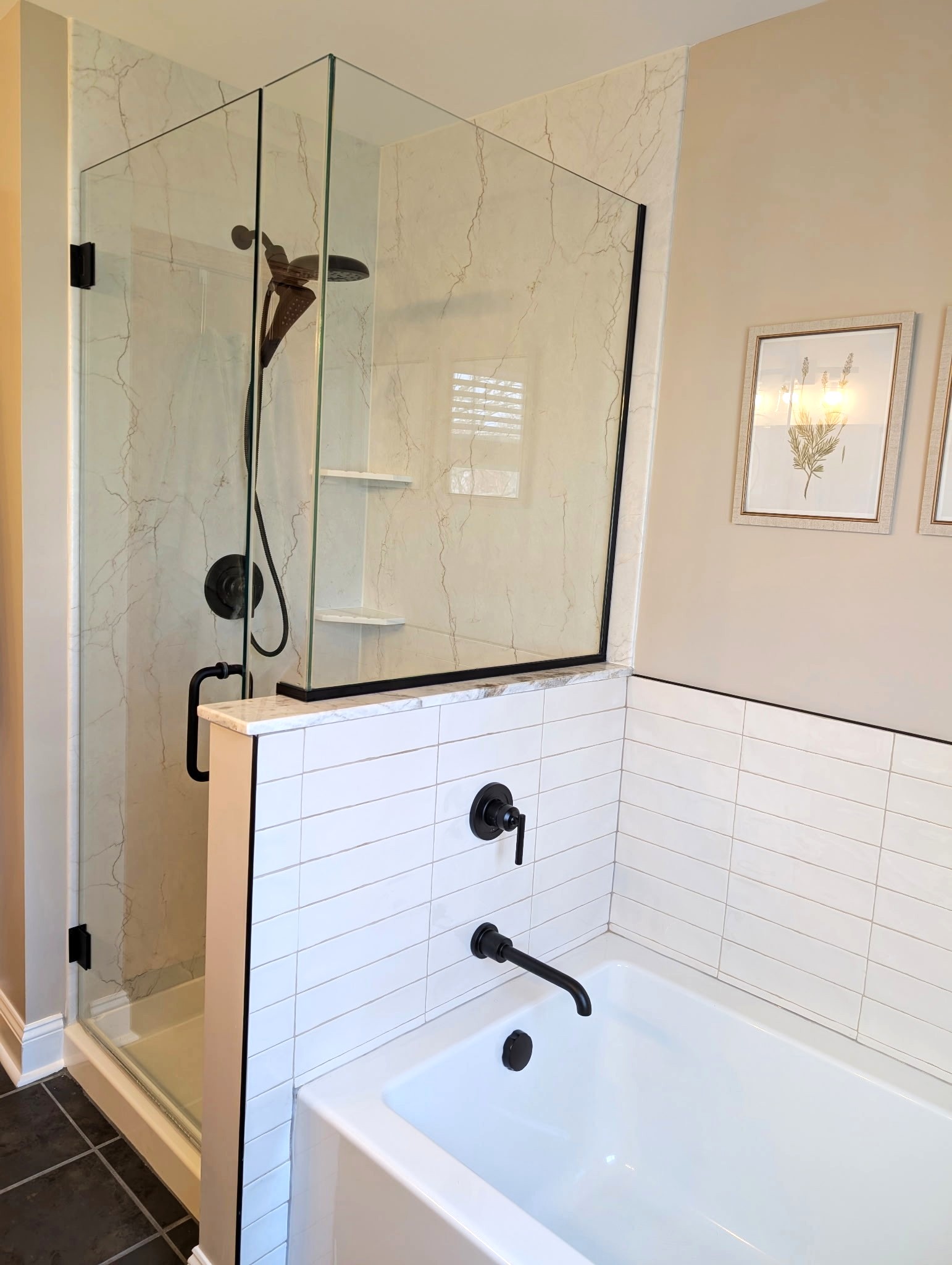 Recently remodeled bathroom with a combined shower and tub, marble-look wet wall panels, matte black hardware and fixtures, and a clean, neutral color scheme creating a modern, minimalist feel.